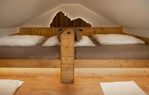 two beds in a loft room with wooden floors at Apartments Rondula Pic in Santa Cristina in Val Gardena