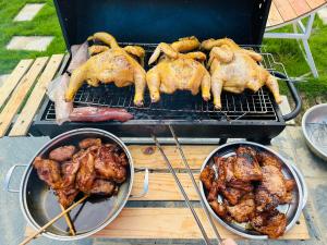 trzy kurczaki i mięso gotują na grillu w obiekcie Homestay Bài Văn garden w mieście Ba Vì District