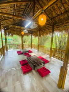 a large room with red cushioned chairs and tables at Homestay Bài Văn garden in Ba Vì