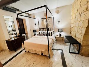 a bedroom with a canopy bed and a mirror at Charming Townhouse Prime Area Valletta in Valletta