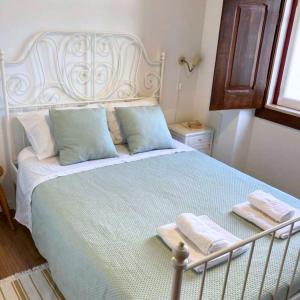 1 dormitorio con 1 cama grande y 2 toallas. en Casa da Vila en Vila Nova da Barquinha