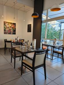 una sala da pranzo con tavoli, sedie e finestre di Hôtel de La Poste a La Cavalerie