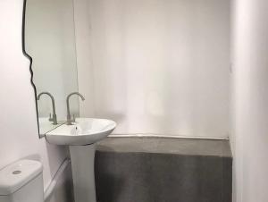 een witte badkamer met een wastafel en een spiegel bij ASHTARAK REST ZONE in Ashtarak
