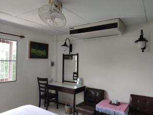 a bedroom with a desk and a mirror and a fan at Changpuak Hotel in Chiang Mai
