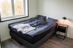 a bed sitting in a room with a window at Modern Fjord View Apartment in Tromsø