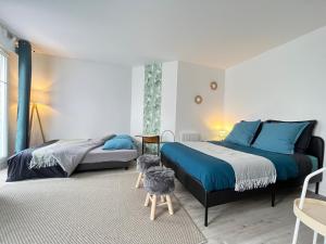 - une chambre avec 2 lits et un chien sur un tabouret dans l'établissement Studio Bienvenue - Louez L'Esprit Libre !, à Bussy-Saint-Georges