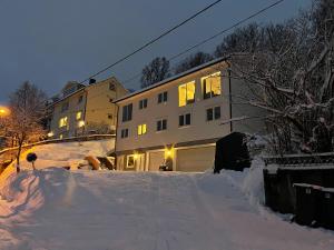 a building with a lot of snow in front of it at Modern Fjord View Apartment in Tromsø