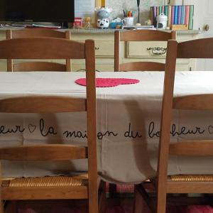 a table with a white table cloth on top of two chairs at Le vieux pré de la motte in Villers-sur-Mer