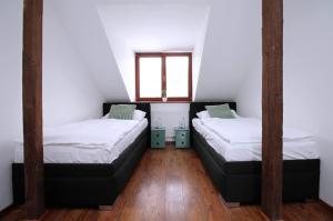 two beds in a room with a window at Penzion u Zajíčku in Horákov