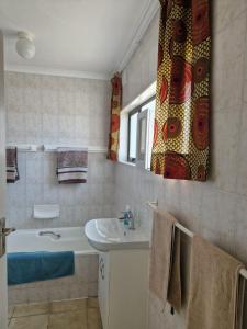 a bathroom with a sink and a bath tub at Umdloti Beach Apartment in Umdloti