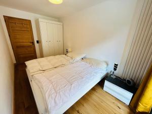 ein kleines Schlafzimmer mit einem Bett und einem Holzboden in der Unterkunft Appartement Les Gets, 2 pièces, 4 personnes - FR-1-623-271 in Les Gets