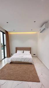 um quarto branco com uma cama com um tapete grande em Akira Chalet em Billah