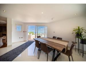 a dining room with a large wooden table and chairs at Gwel An Keynvor Penthouse in Newquay