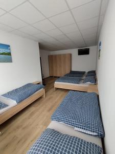 a room with four beds and a flat screen tv at UBYTOVŇA BYTČA in Bytca