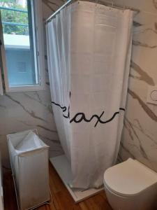 a bathroom with a toilet and a shower curtain at La Casetta Riviera Citra 008065-LT-0424 in Ventimiglia