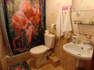 a bathroom with a toilet and a sink and a shower curtain at Flamingo 