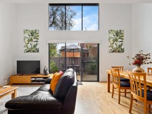 a living room with a black leather couch and a table at Townhouse 212 in Margaret River Town