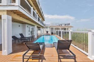 une terrasse avec des chaises et une piscine dans une maison dans l'établissement 2876 - The Blue Martini by Resort Realty, à Duck