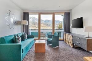 a living room with a blue couch and a television at Alpine Club in Schladming