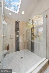 uma casa de banho com um chuveiro e uma porta de vidro em Luxury Modern Waterfront Retreat em Montross