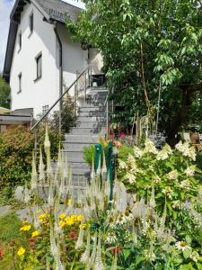 a garden with flowers and stairs in front of a house at Wildes Paradies,135 qm Ferienwohnung im Naturgarten in Chemnitz