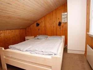 Nørre VorupørにあるThree-Bedroom Holiday home in Thisted 9の木製の壁のドミトリールームのベッド1台分です。