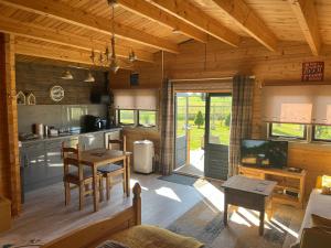 a kitchen and living room of a log cabin at Rife Lodges in Arundel