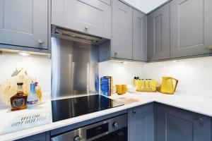 uma cozinha com armários brancos e um forno com placa de fogão em Belle Vue Regency King size w Free Parking em Cheltenham