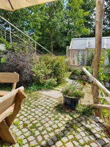 un jardín con un banco y una casa en Wildes Paradies,135 qm Ferienwohnung im Naturgarten en Chemnitz