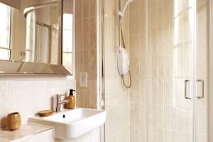 een witte badkamer met een wastafel en een douche bij Belle Vue Regency King size w Free Parking in Cheltenham