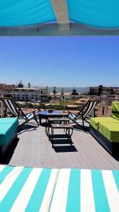 a patio with a table and benches and a view of the beach at Riad Ocean Medina in Essaouira