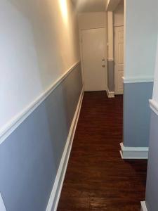 un pasillo vacío con una pared blanca y una puerta en Nice and quiet appartement en Filadelfia