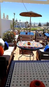 a patio with a table and chairs and an umbrella at Riad Ocean Medina in Essaouira