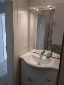 uma casa de banho com um lavatório branco e um espelho. em Ferienwohnung Michelle em Bremerhaven