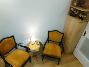 um quarto com duas cadeiras e uma mesa com um candeeiro em New apartment BARNABA close to Holiday Inn em Tbilisi
