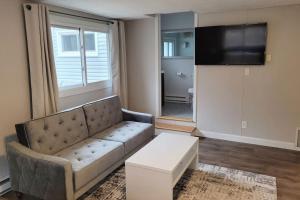 a living room with a couch and a flat screen tv at Door County Cottage, near Haines Beach! in Sturgeon Bay