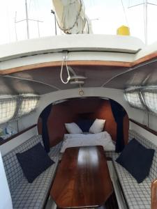 un letto e un tavolo sul retro di una barca di Vintage Sailboat in Belém a Lisbona