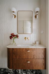 een badkamer met een wastafel en een spiegel bij Przy Przystani Apartament Paryski in Wrocław