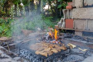 a fire pit with food on it in a yard at D&D Holiday Home in Supetar