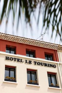 Un hotel yace girando un cartel en un edificio en Hôtel le Touring en Saint-Raphaël