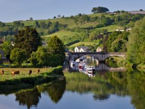 a bridge over a river with boats in the water at Mulberry Cottage in Totnes