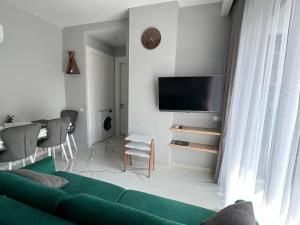 sala de estar con sofá verde y TV en The Yacht apartments en Alanya
