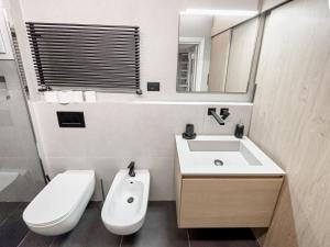 y baño con lavabo, aseo y espejo. en Realkasa Bolognetti Apartment, en Bolonia