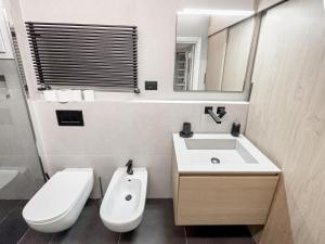 een badkamer met een wastafel, een toilet en een spiegel bij Realkasa Bolognetti Apartment in Bologna
