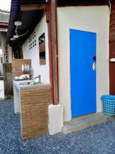 una puerta azul en el lateral de un edificio con fregadero en Grandma’s House, en Chiang Mai