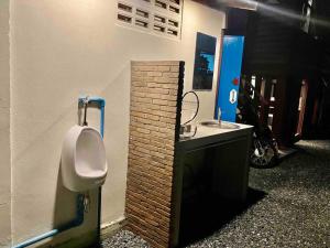 a public bathroom with a urinal and a sink at Grandma’s House in Chiang Mai