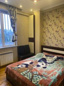 Cheerful Apartment في تبليسي: غرفة نوم بسرير وكرسي ونافذة