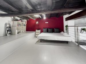 een slaapkamer met een groot bed met een rode muur bij Realkasa Bolognetti Apartment in Bologna