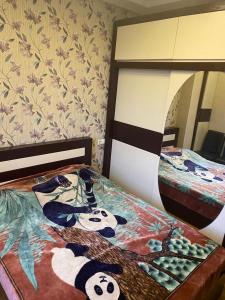 Cheerful Apartment في تبليسي: غرفة نوم بسريرين مع باندا على السرير