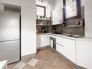 een witte keuken met een wastafel en een koelkast bij Realkasa Bolognetti Apartment in Bologna +7 foto's